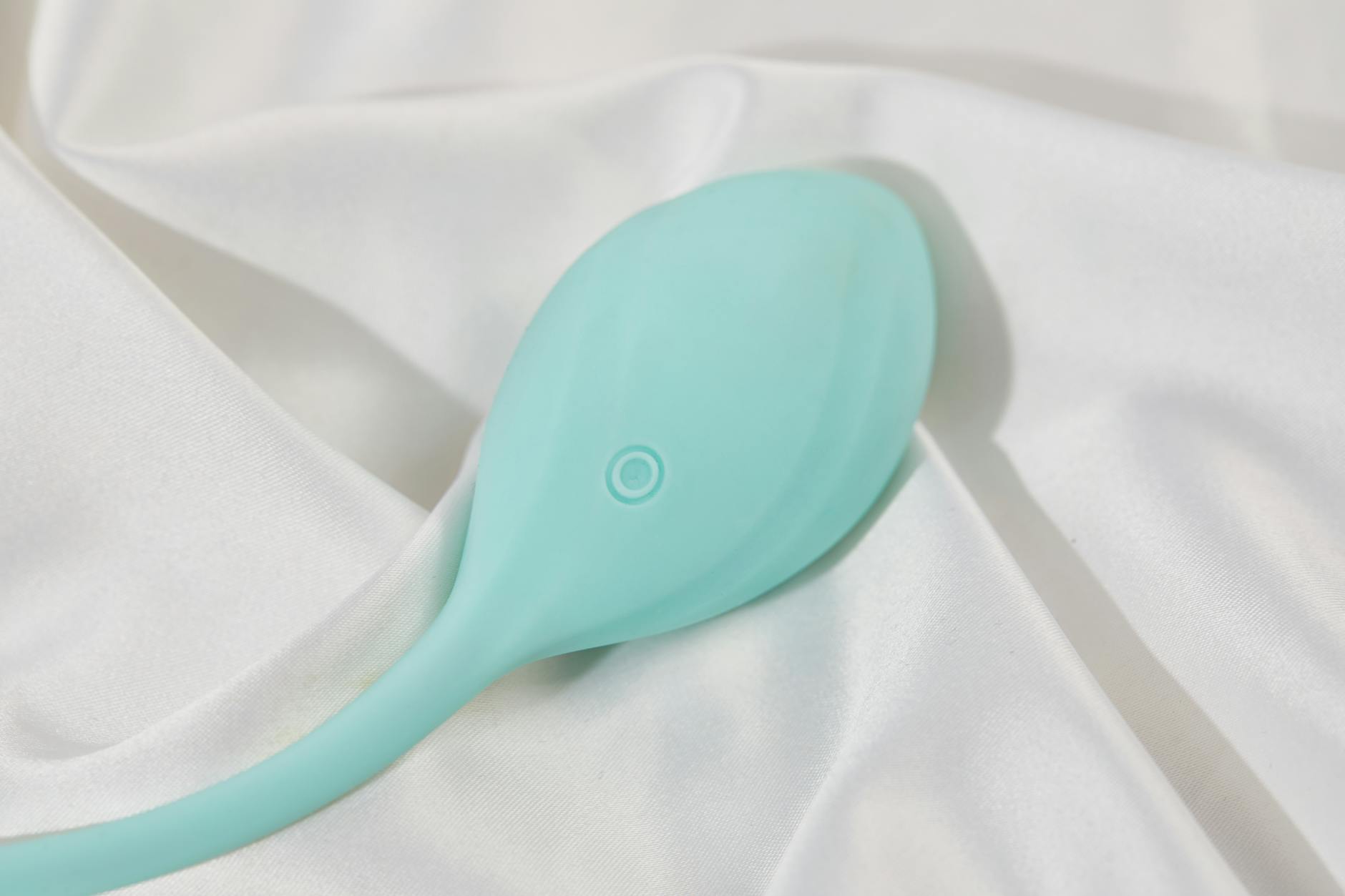 Ein eleganter Lemon-Vibrator auf weißem Stoff, Symbol für sanfte Wiederentdeckung von Lust