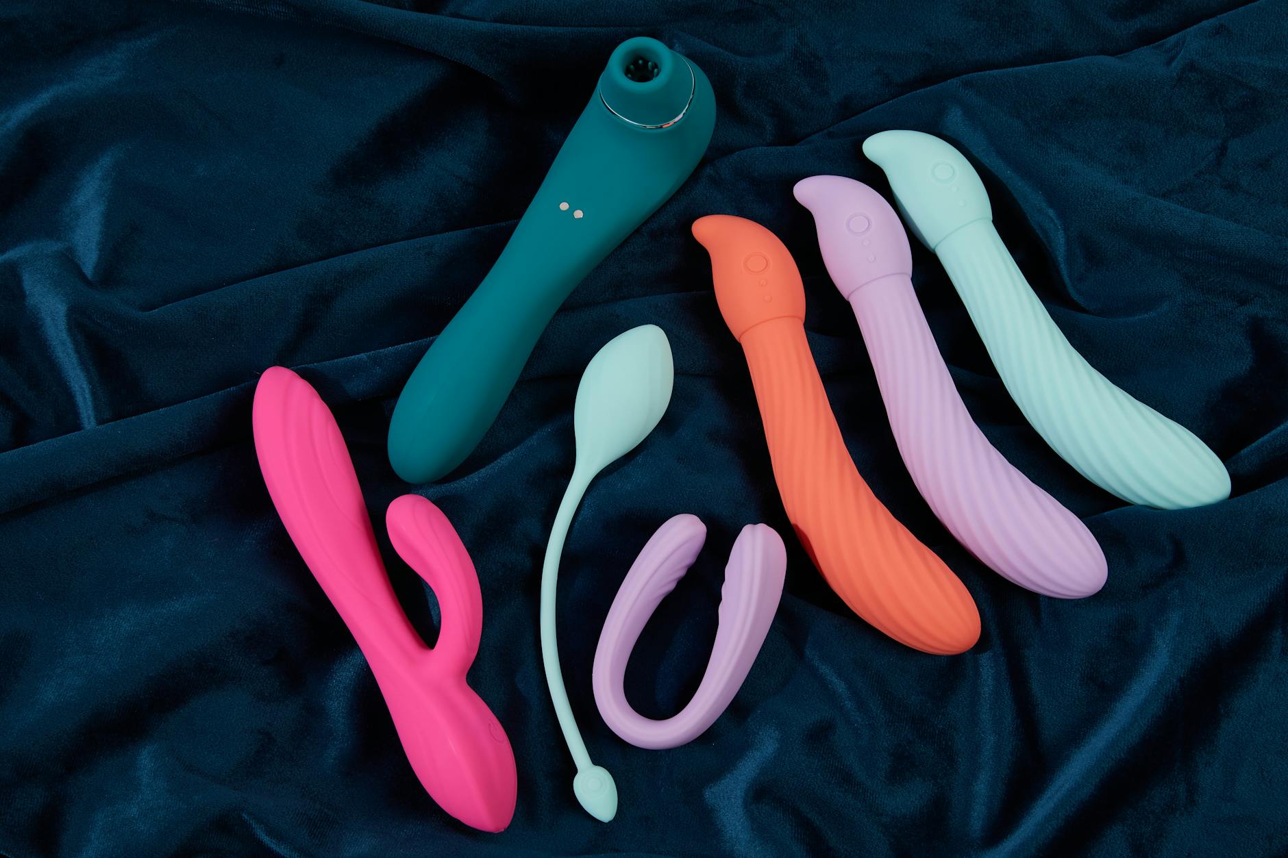 Ein junges Paar steht zusammen, hält einen blauen Vibrator in der Hand und erkundet gemeinsam moderne Intimität