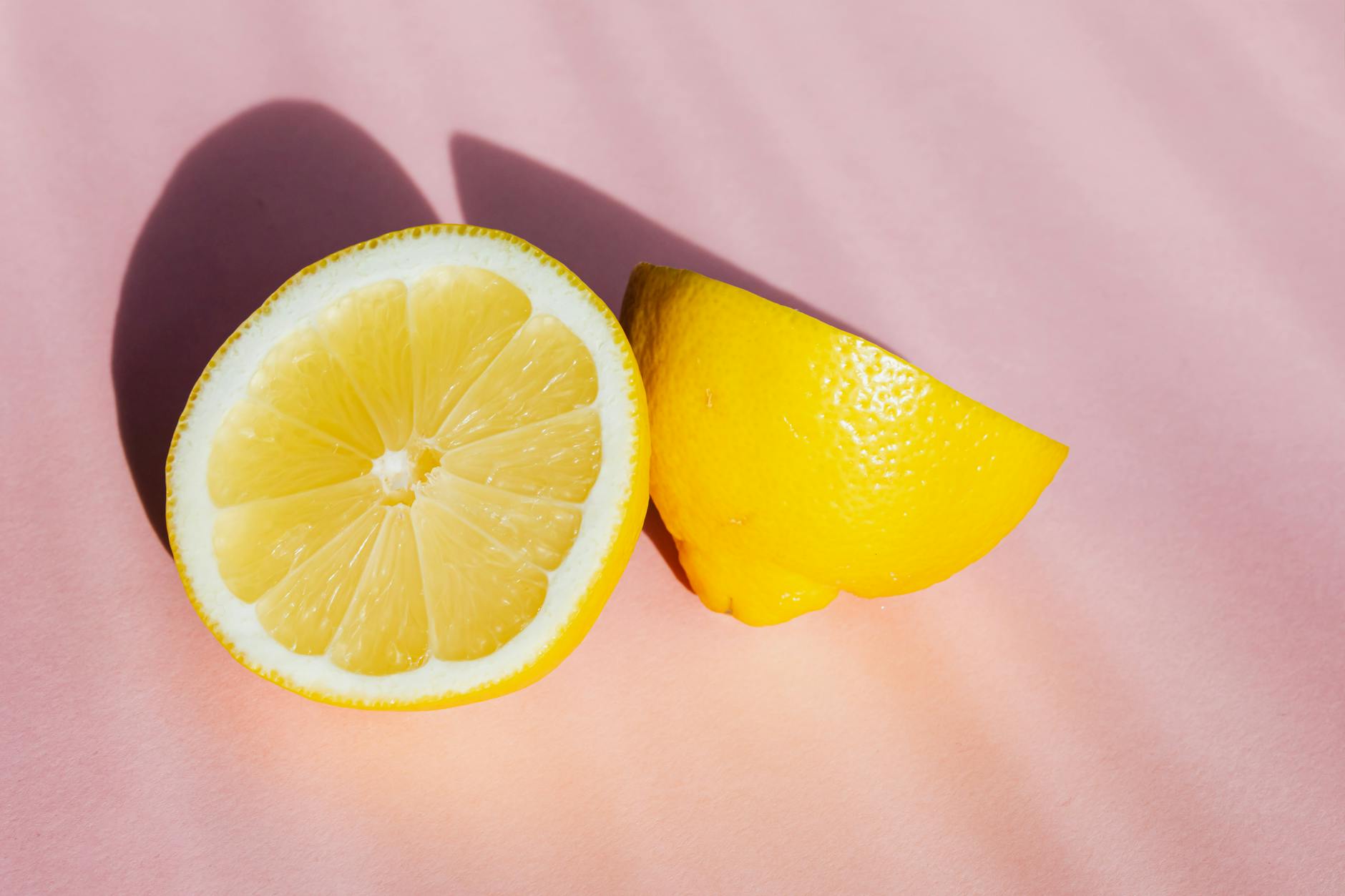 Hand hält einen orangefarbenen Saugvibrator vor minimalistische violette Kulisse, modern und sinnlich