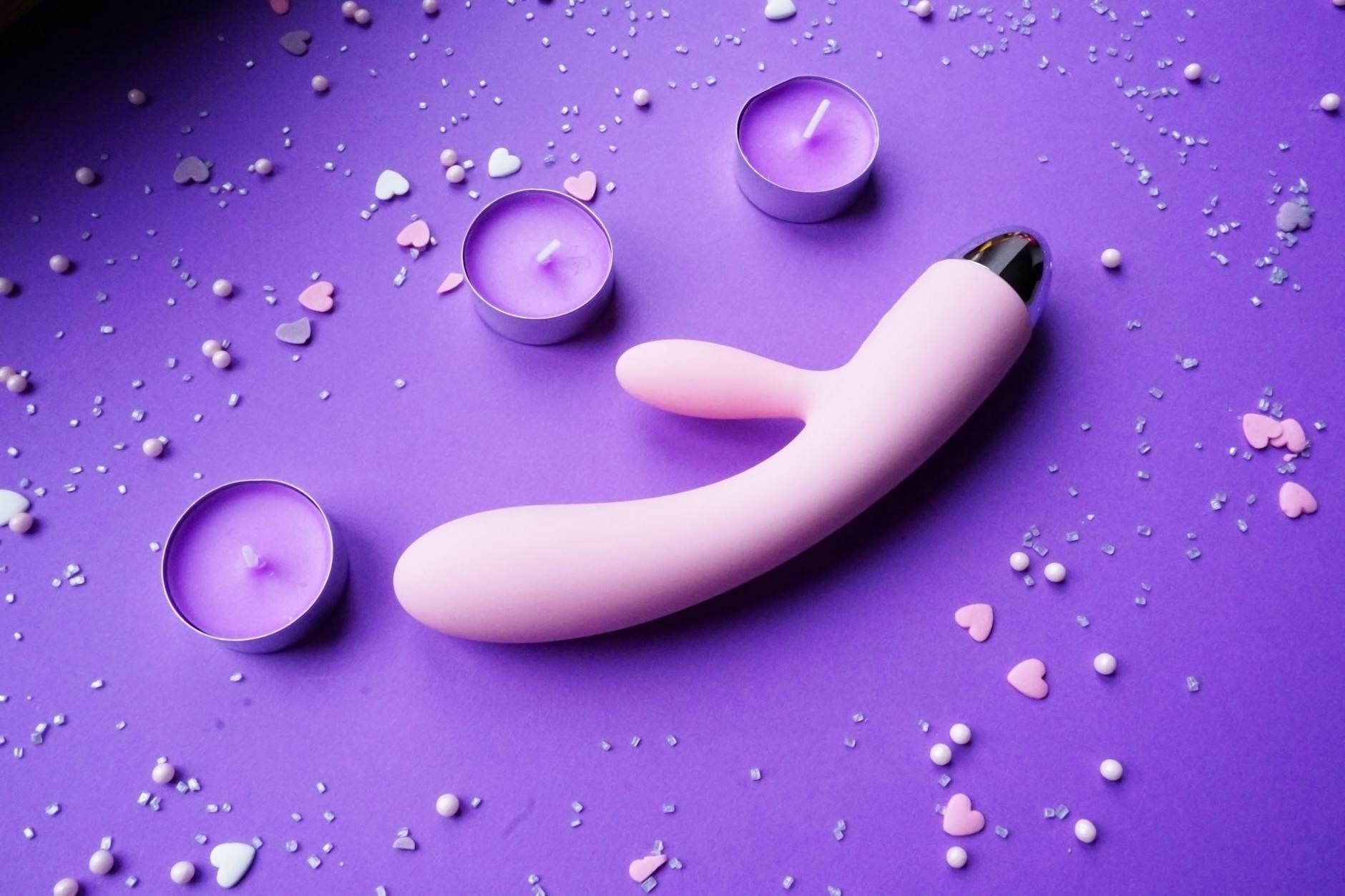 Junges Paar, das zusammen einen Vibrator in der Hand hält und moderne Intimität teilt