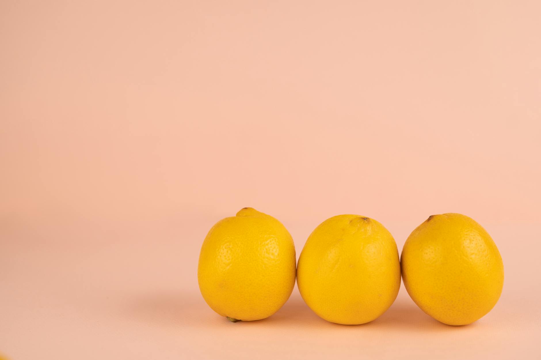 Ein blauer Vibrator umgeben von Blumen und Orangenscheiben auf gelbem Hintergrund
